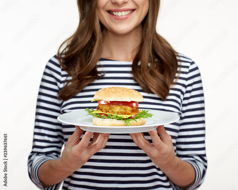 woman holding burger on white plate.