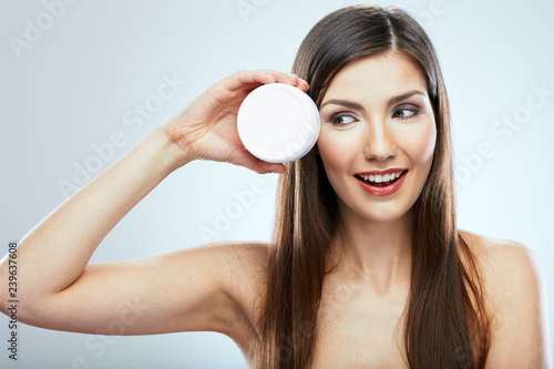 Beauty portrait of young woman holding skin care product.