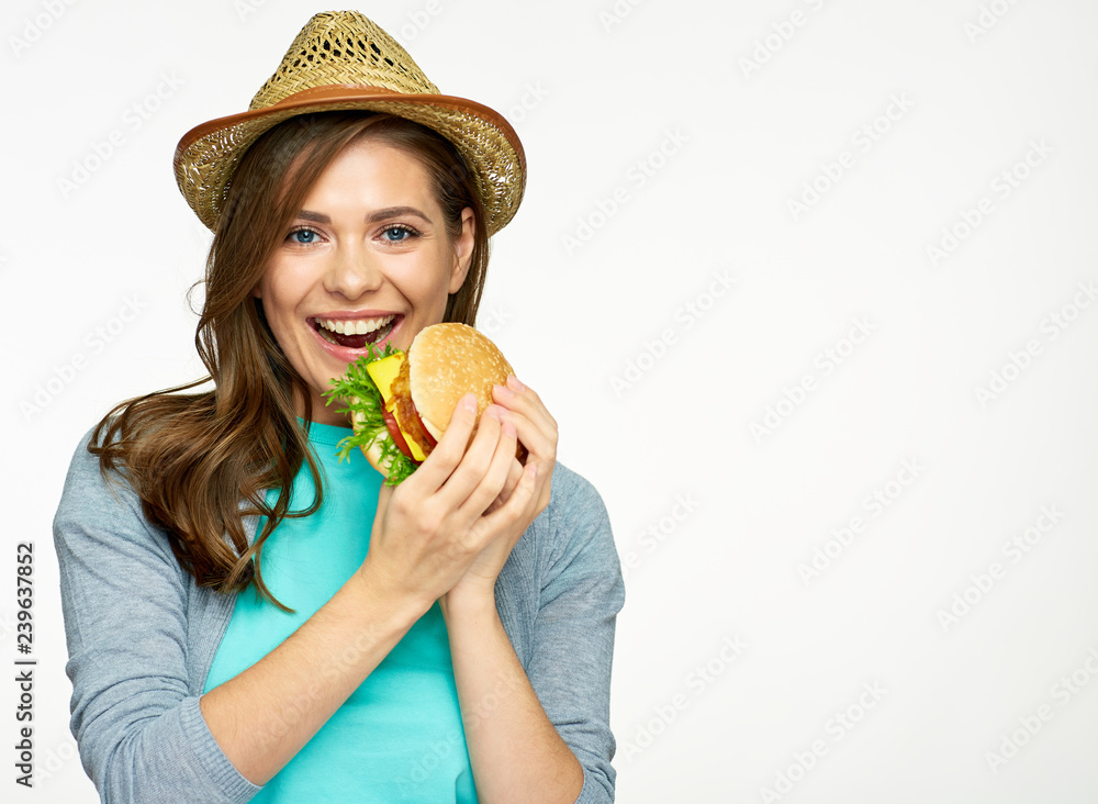 portrait of woman wearing summer hat eating burger. portrait of woman wearing summer hat eating burger.