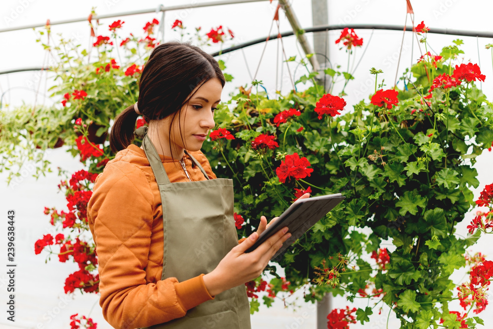 Young florist holding digital tablet