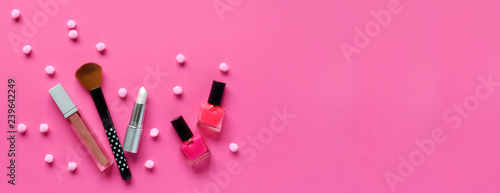 Nail polishes, lipstick on a pink background. Makeup cosmetics for young women or teenager. Copy space. Top view
