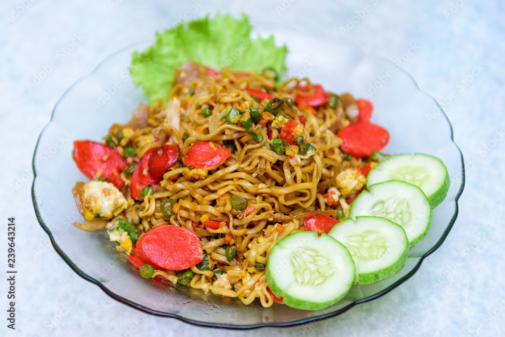 Home made style fried noodles with beef sausage, vegetables, scrambled eggs, meat balls and minced chicken being pulled using chopsticks by hand Home made style fried noodles with beef sausage, vegetables, scrambled eggs, meat balls and minced chicken being pulled using chopsticks by hand