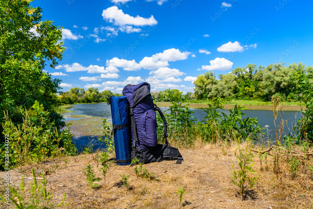 Touristic backpack on a bank of river Touristic backpack on a bank of river