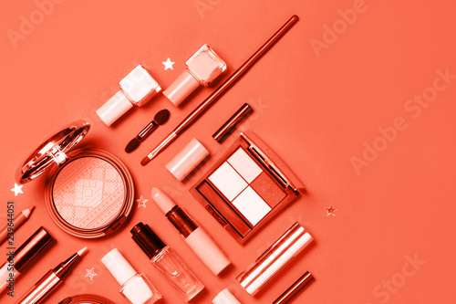 Living Coral colored Decorative cosmetic and nail polishes set on coral background. Minimalism cosmetics style. Top view, flat lay. Creative fashion beauty concept of color of the year 2019. 16-1546 photo