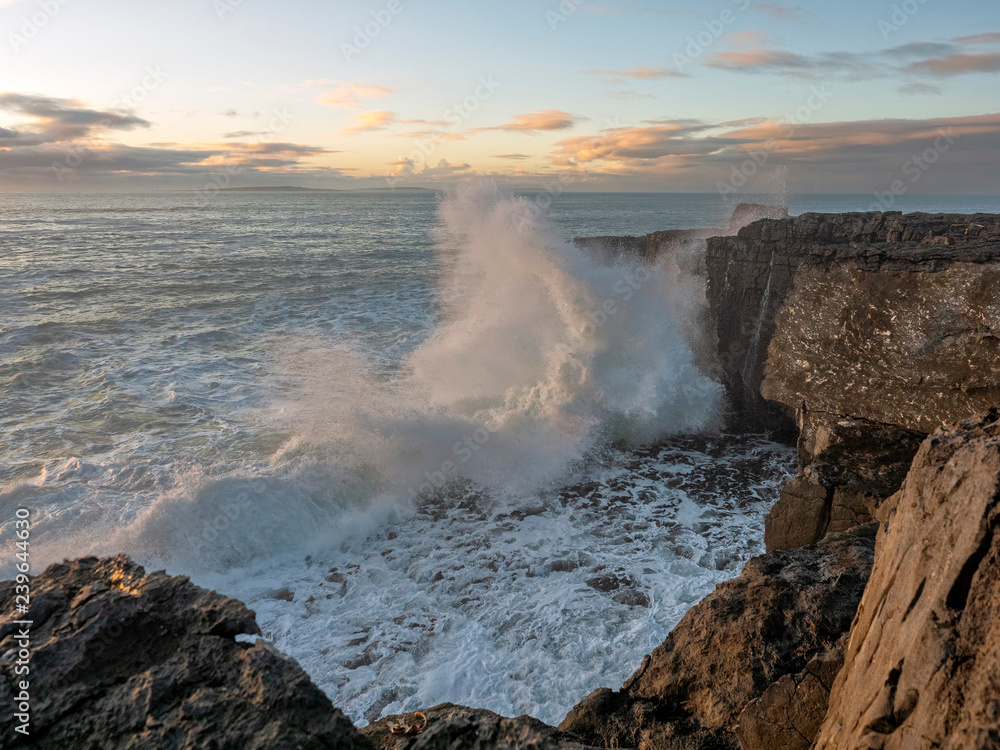 Huge waves crashing on rocks at sunset, storm, West coast of Ireland.