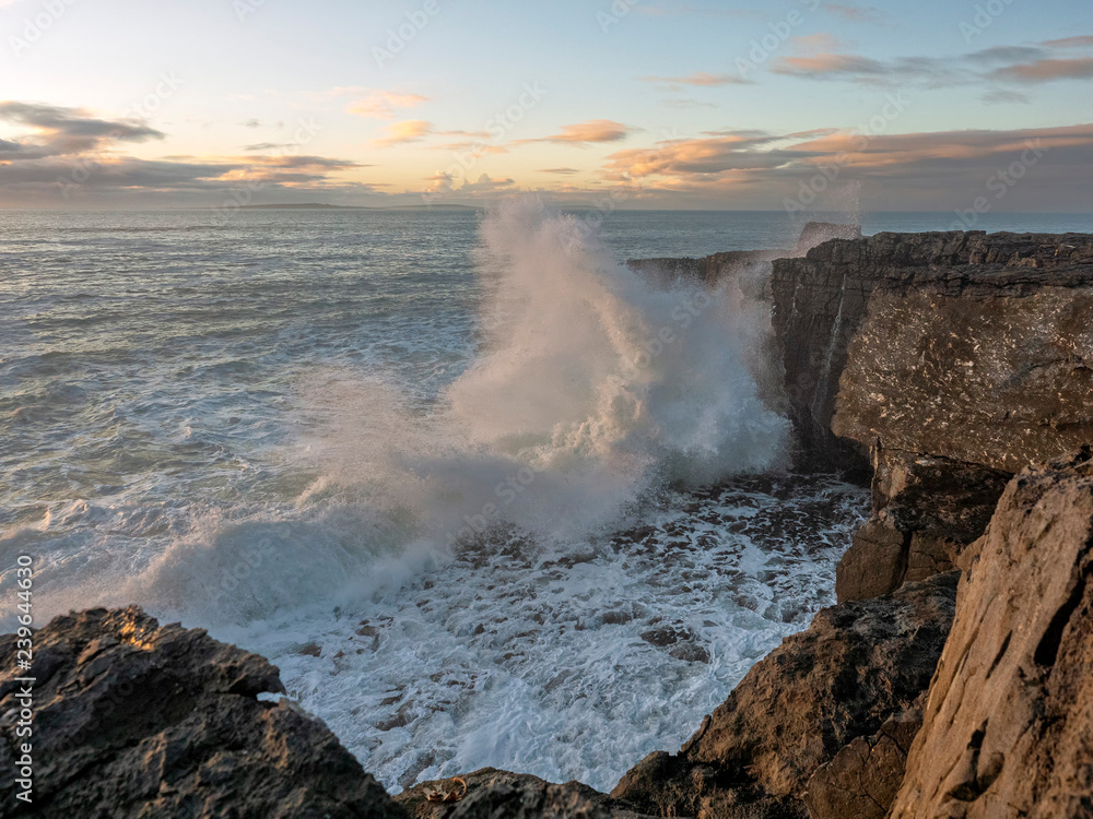 Fototapeta premium Huge waves crashing on rocks at sunset, storm, West coast of Ireland.
