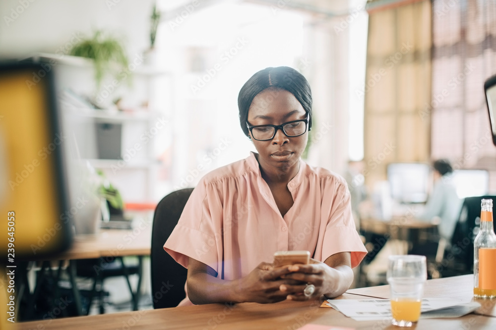 Businesswoman using mobile phone in office Businesswoman using mobile phone in office