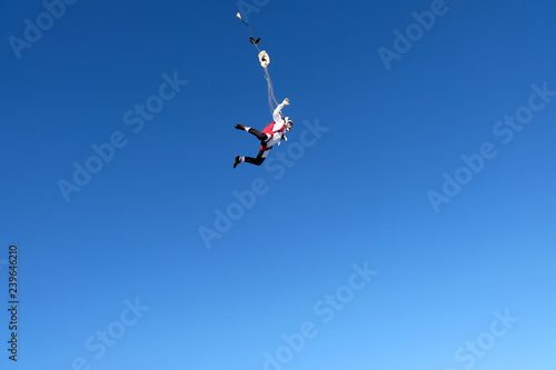 Skydiver is in the blue sky.