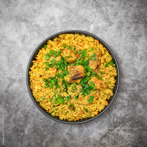Rice pilaf with meat carrot and onion on grey background. Top view