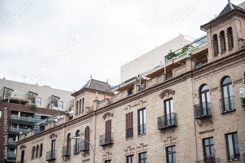 Exterior of a local building in Spain. The building seems to be a mix of old and modern architecture. The Streets seem to be narrow. It seems to be a sunny day.