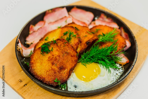 Potato pancakes with fried egg, bacon and dill