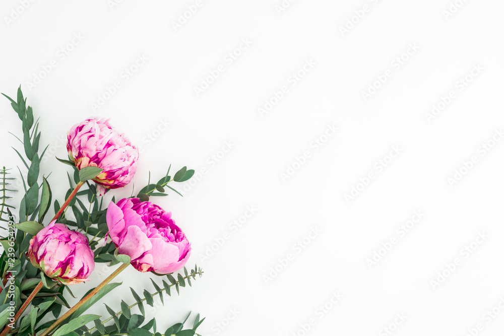 Fototapeta premium Floral bouquet of pink peonies, hypericum and eucalyptus on white background. Flat lay, top view