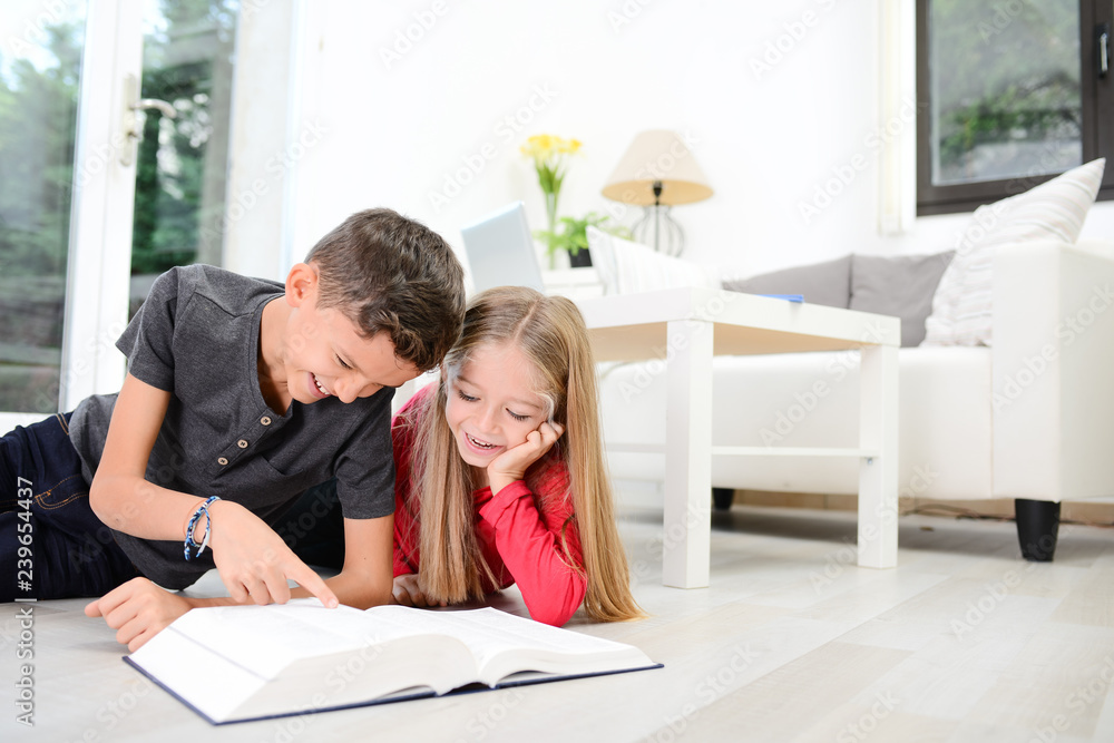 two young happy kids brother and sister together having fun at home reading encyclopedia book two young happy kids brother and sister together having fun at home reading encyclopedia book