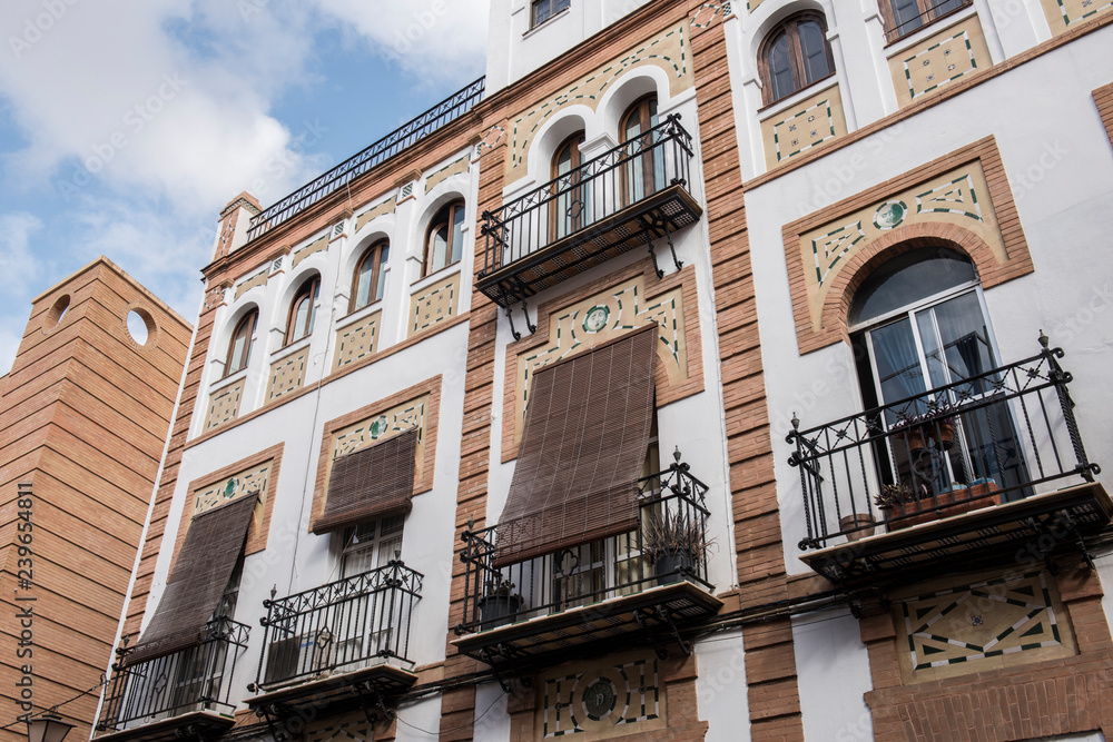 Exterior of a local building in Spain. The building seems to be a mix of old and modern architecture. The Streets seem to be narrow. It seems to be a sunny day.