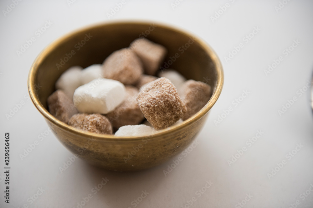 In this closeup we can see sugar cubes being kept in a bowl to be served. Several sugar cubes can be seen and the white table is noticed too. In this closeup we can see sugar cubes being kept in a bowl to be served. Several sugar cubes can be seen and the white table is noticed too.