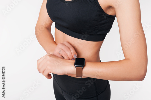 Young woman checking progress on smart watch. Female fitness looking at smart watch heart rate monitor.