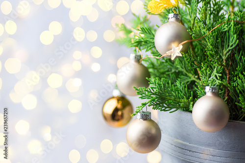 Beautiful Christmas New Year Background. Decorated potted juniper branches ornament balls golden garland bokeh lights. Festive atmosphere. Poster banner card template. Shallow depth of field