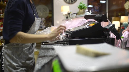 The Seller at the Grocery Store weighs a Cheese and clicks on the Cash Register