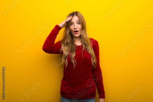 Young girl on vibrant yellow background has just realized something and has intending the solution
