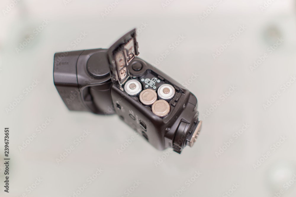 Batteries inserted in a black flashgun flashlight on a white background isolated Batteries inserted in a black flashgun flashlight on a white background isolated