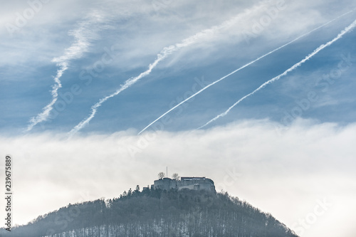 Burg Hohenneuffen mit dramatischem Wolkenhimmel und Kondensstreifen