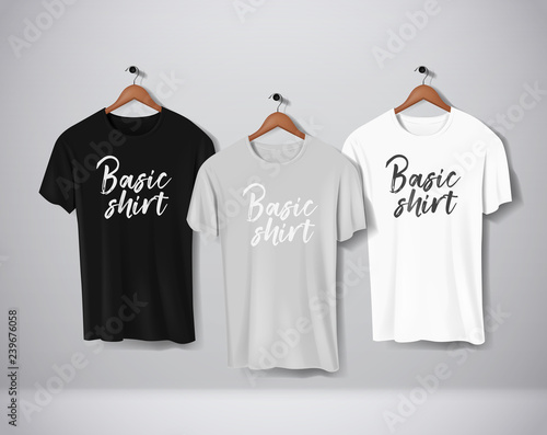 Basic Black, gray and white short sleeve T-Shirts Mock-up clothes set hanging isolated on wall. Front side view with lettering for your design or logo.