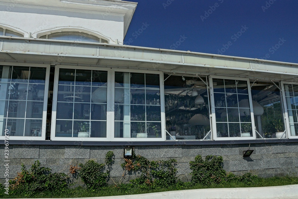 Fototapeta premium long white window on the facade of the building against the blue sky