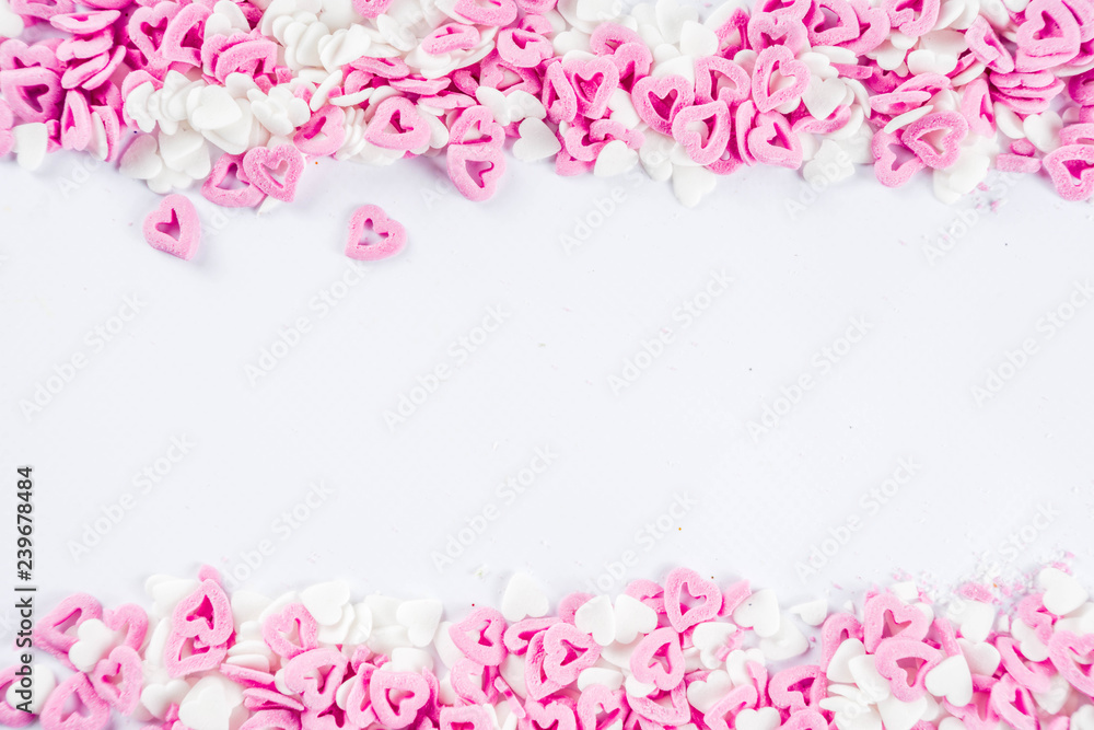 Valentine's sweets background, white background with sugar hearts sweet sprinkles, copy space top view, layout on white
