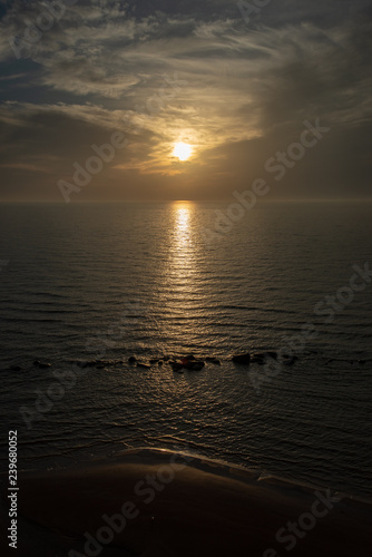 dramatic high contrast clouds in sunset over seaside beach