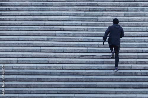  Athletic young man runs up the stairs.