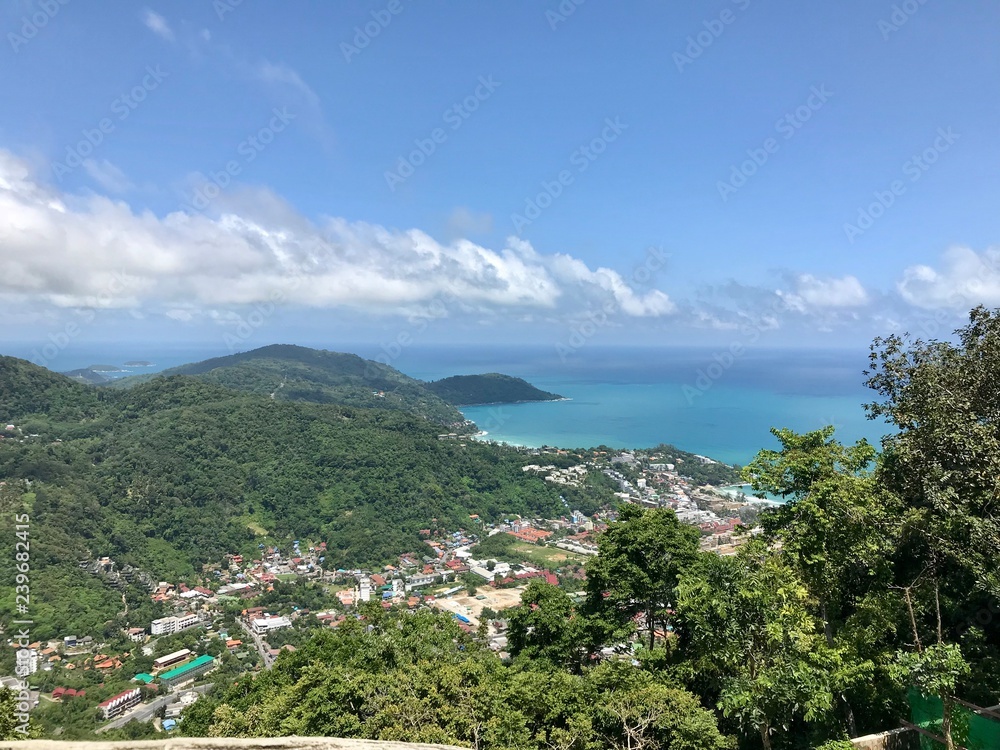 Panoramic view of the island Phuket, Thailand. Beautiful landscape of nature and azure sea. Amazing clouds on the sky. Panorama from the height. Image from the viewpoint of tropical costal resort. 