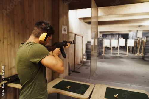 Man aiming with rifle in shooting range