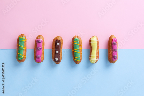 Obraz na plátně French eclairs on pink and blue divided background