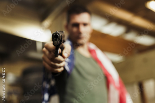 Close-up of man wearing American flag aiming with a gun