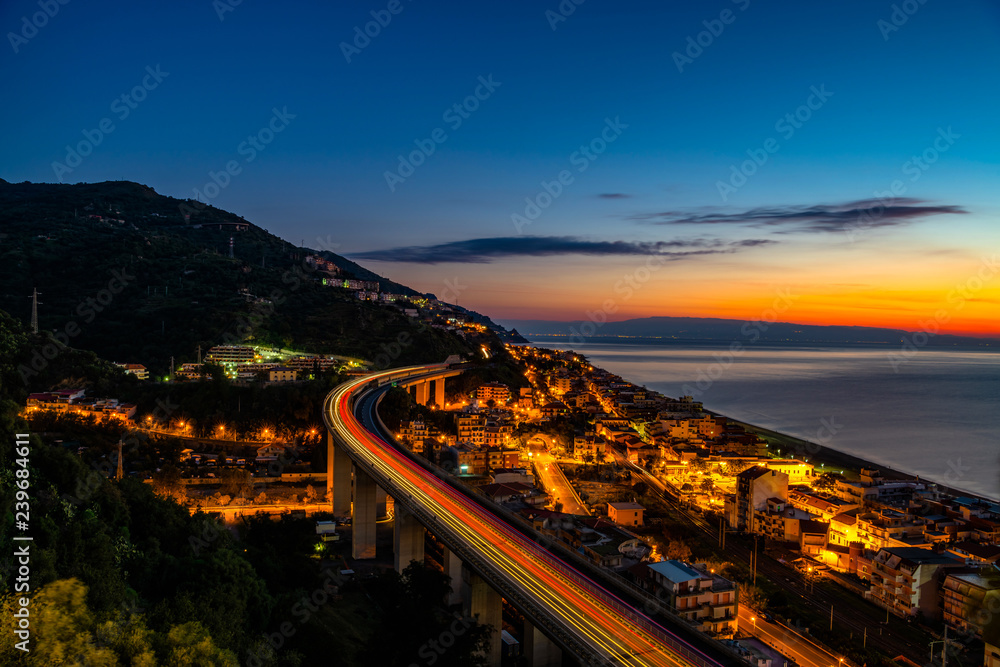 Panoramic view of highway and coastal city by night, Sicily,Italy