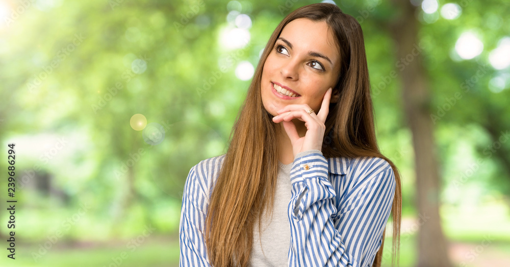 Young girl with striped shirt thinking an idea while looking up at outdoors Young girl with striped shirt thinking an idea while looking up at outdoors