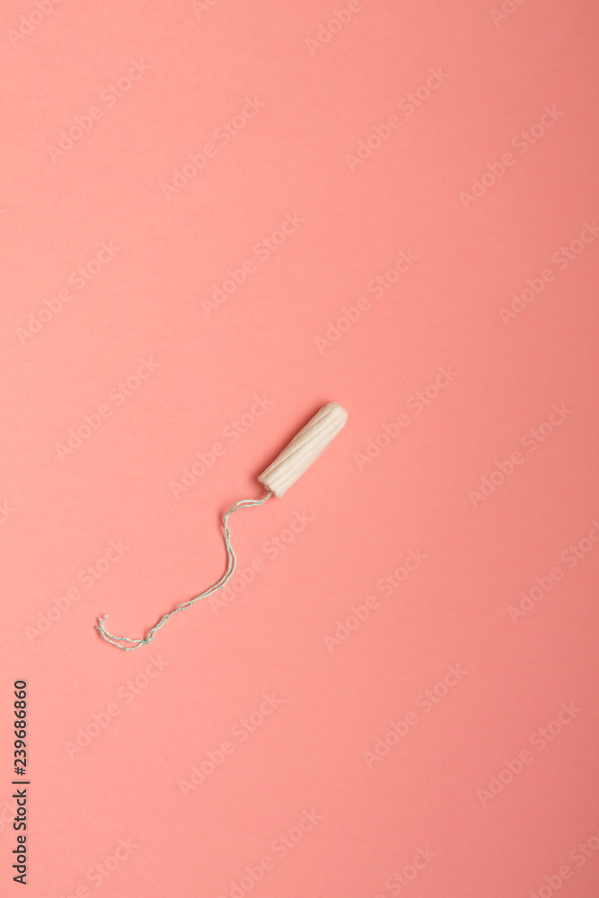 Menstrual cycle, feminine care, menstruation and intimate products concept with internal tampon isolated on pink background with copy space Menstrual cycle, feminine care, menstruation and intimate products concept with internal tampon isolated on pink background with copy space
