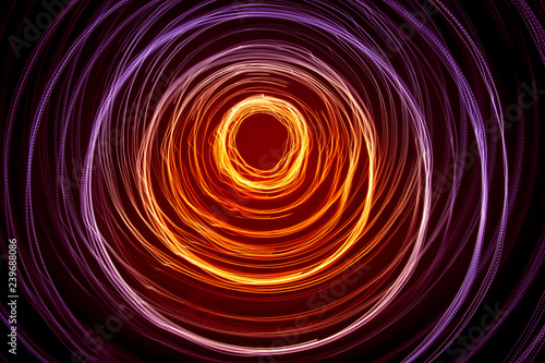A beautiful, bright light swirl of colors. Futuristic light painting on a black background. Round light circles