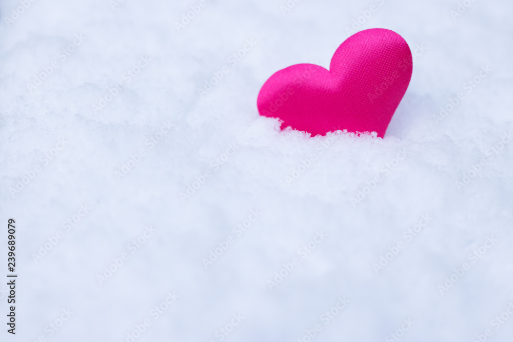 Decorative pink heart on white snow background with copy space for message. Concept: love winter season. 
