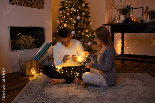 Wallpaper Mural Couple in love near nicely decorated Christmas tree, enjoying the Christmas magic. Torontodigital.ca