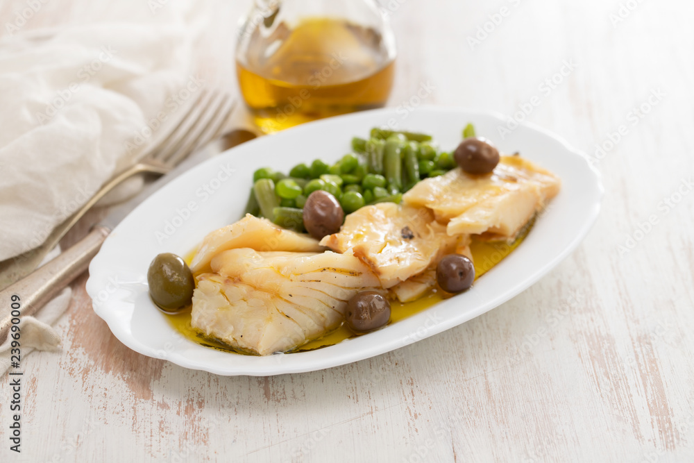 fried cod fish with peas and green beans on white dish
