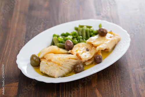 fried cod fish with peas and green beans on white dish