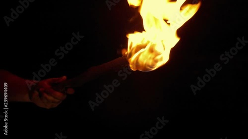 Person Holds Up Burning Torch In The Dark