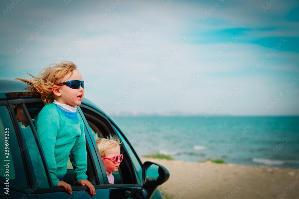 happy kids enjoy travel by car at sea