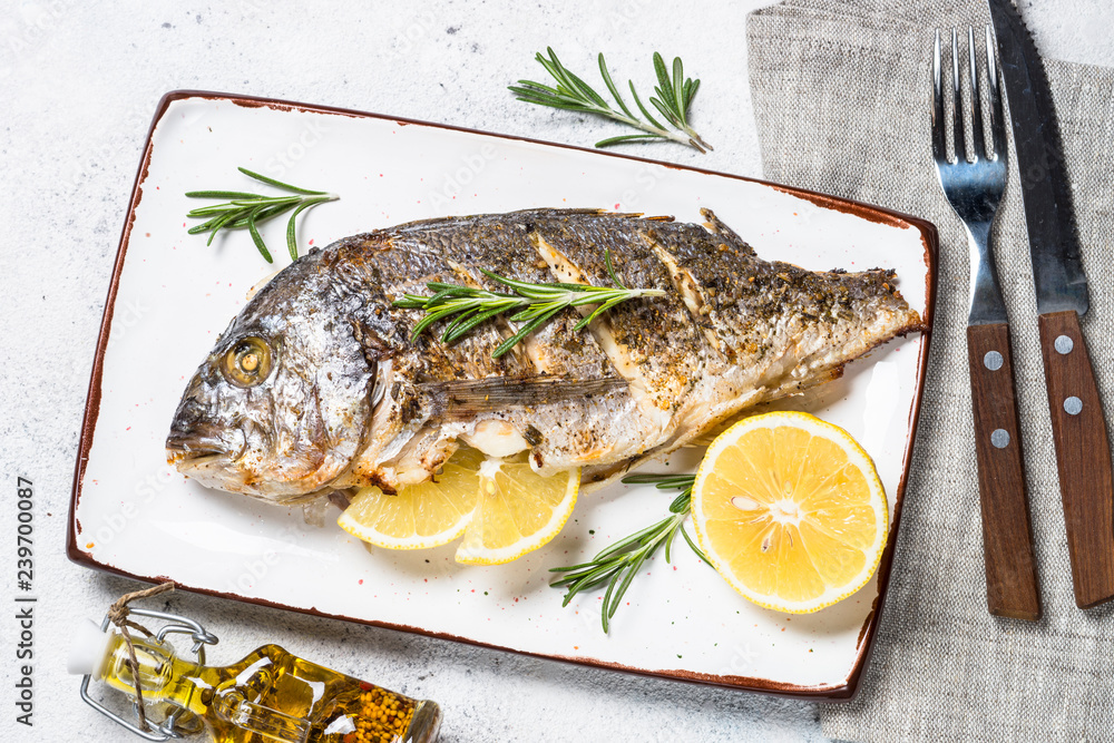 Baked dorado fish with lemon and rosemary top view. Baked dorado fish with lemon and rosemary top view.