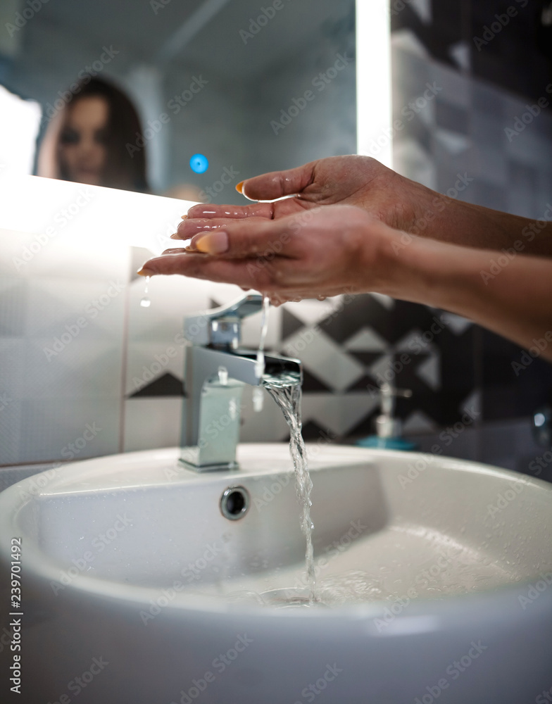 The girl washes her hands and splashes water in the sink in the incredibly beautiful bathroom with a magic light. The girl washes her hands and splashes water in the sink in the incredibly beautiful bathroom with a magic light.