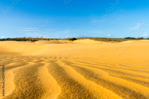 Wave on sand dune with clear blue sky at Mui Ne, Vietnam.