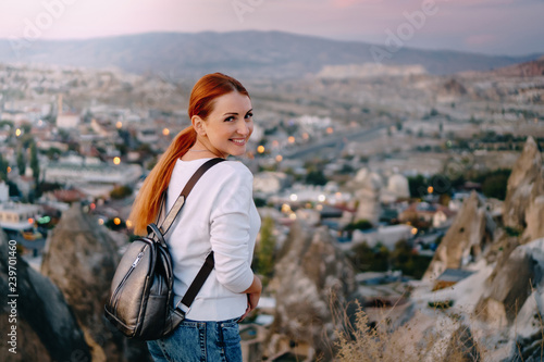 happy woman tourist is standing against mountain landscape