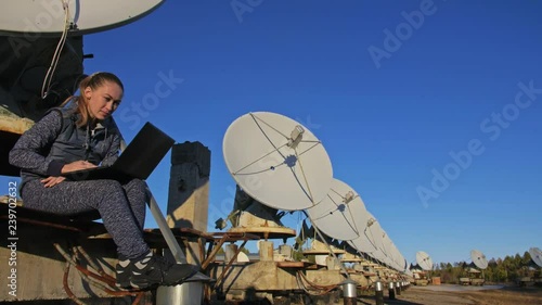 Woman student operator of institute of Solar Terrestrial Physics monitors communication equipment in notebook. Unique array solar radio telescope. Sun Solar Radio Telescope. The 'Quasar' observatory photo