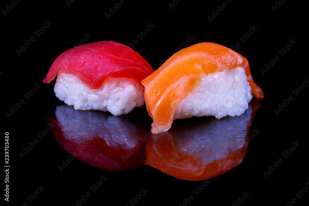 A couple of Salmon and akami tuna sushi on black background with reflection. A couple of Salmon and akami tuna sushi on black background with reflection.